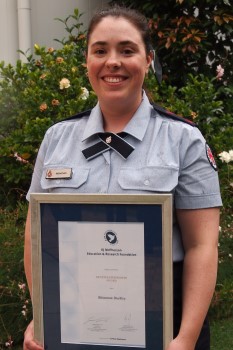 Rhiannon Buckley (female) holding a KJM grant certificate for CPR education.
