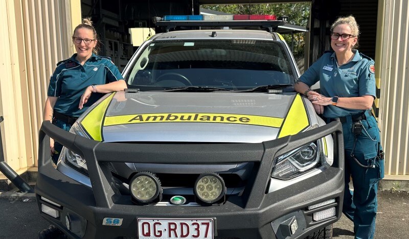 Two QAS falls team members next to a vehicle