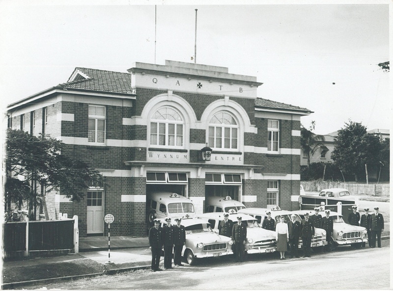 Wynnum Ambulance Centre building with ambulance vehicles and staff. Year unknown.