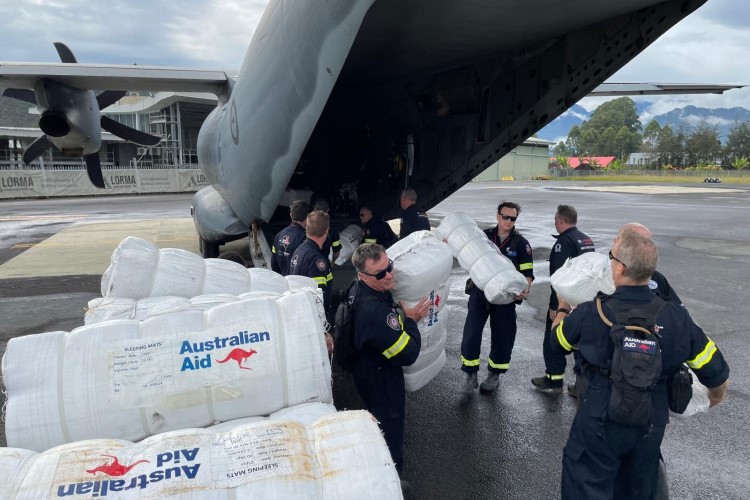 Australian aid team unloading packs from a plane