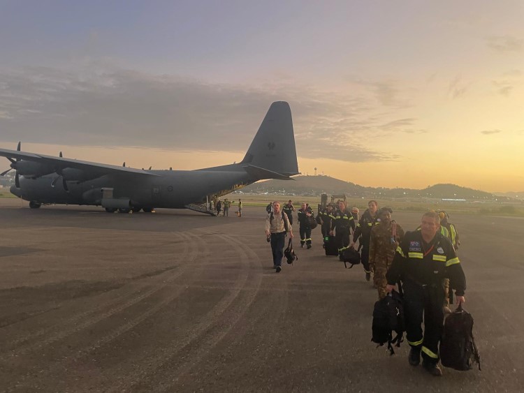 Australian aid team walking away from a plane at sunset