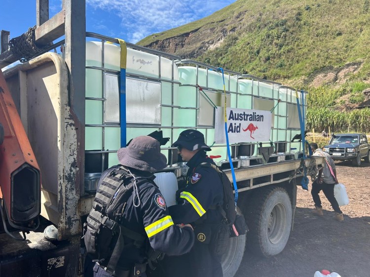 Aid team unloads a truck of drinking water